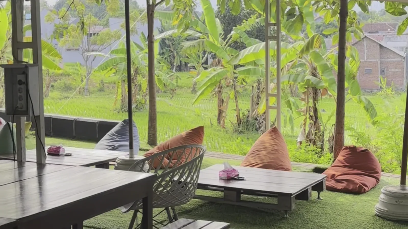Open-air terrace dining overlooking natural rice fields